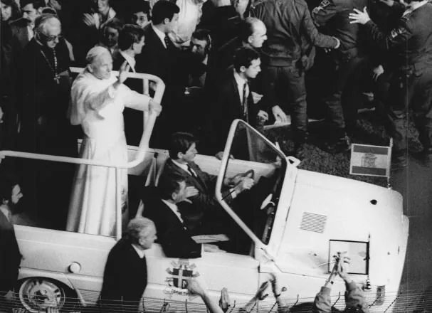 Juan Pablo II saluda desde un papamóvil 