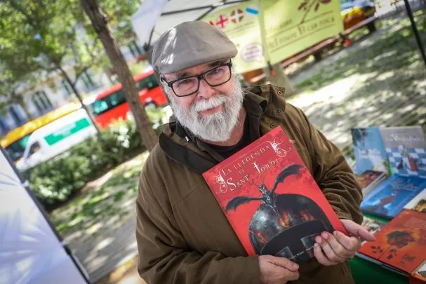 The author Josep Francesc Delgado with his illustrated book at a stall in Arc del Triomf.