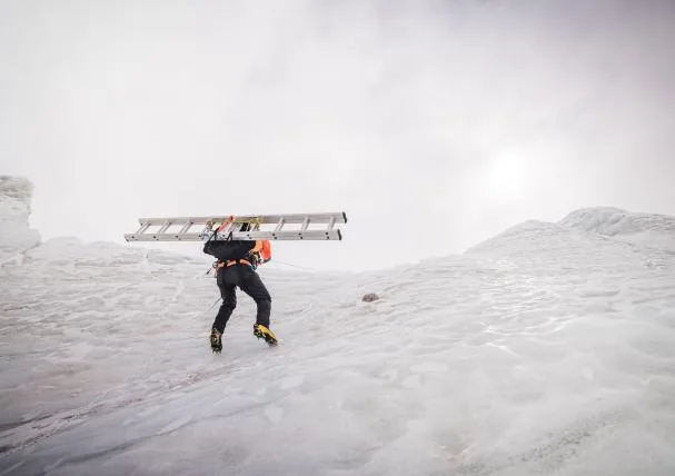 A sherpa carries a ladder to equip the route on the Khumbu glacier