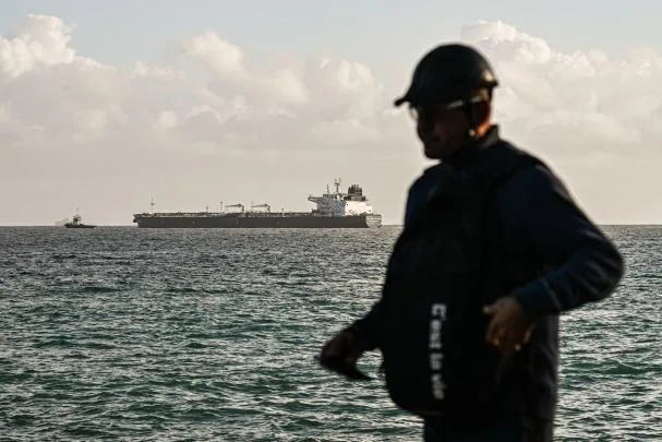 Un cubano pasa por delante del petrolero Anatoly Kolodkin, que fue autorizado a descargar crudo el pasado marzo en el puerto de Matanzas. 