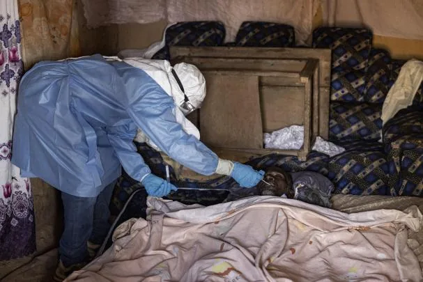 A health worker collects samples from a body suspected of having died of Ebola in Mongbwalu, Ituri locality where the first recorded case of the current emergency occurred