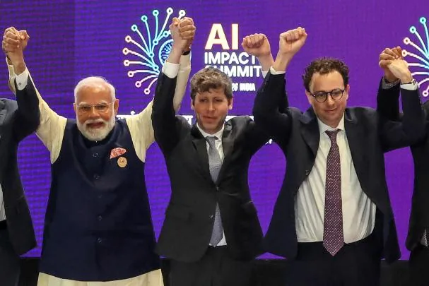 Sam Altman, in the center, alongside Darío Amodei, at a meeting in India (Photo by Ludovic MARIN / AFP)