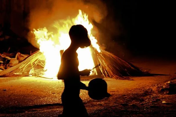 A young man walks past a bonfire in Havana.