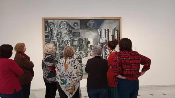 A group of elderly people observe Picasso's Las Meninas