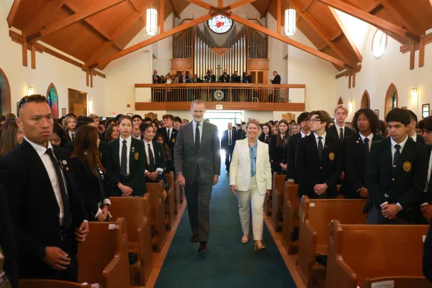 The King enters the assembly hall of Lakefield College, alongside principal Anne-Marie Kee