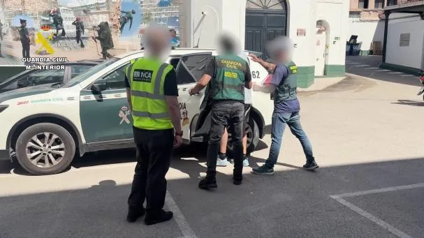 The Civil Guard places one of the detainees in a car.