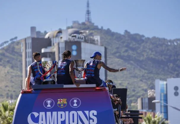 Eric Garcia, Koundé, and Raphinha escort the League and Super Cup trophies