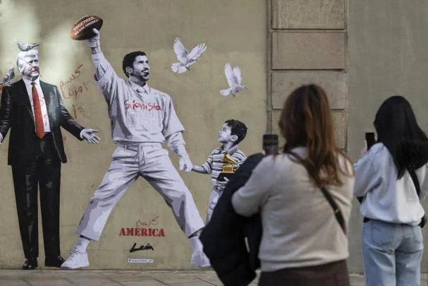 A graffiti by artist Alberto León in downtown Barcelona, advocating peace against the US president with an image of Puerto Rican singer Bad Bunny
