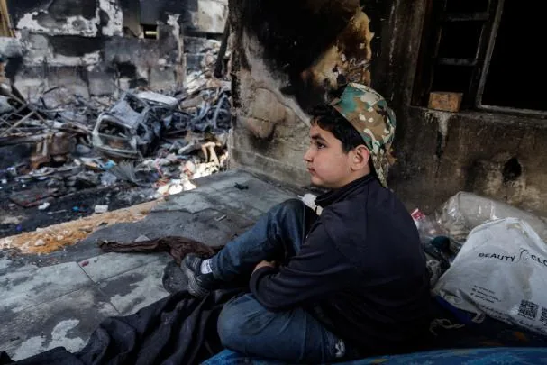 Omar, 13 years old, claims to have survived an Israeli bombing talks with his brother on what remains of the balcony after an airstrike 