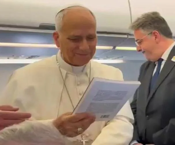 The Pope observes the book 'Leo XIV. A Pope for Turbulent Times', edited by 'La Vanguardia', during the flight to Spain
