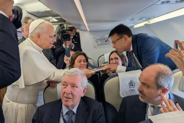 The Pope receives on the plane to Spain the book 'Leo XIV. A Pope for turbulent times', published by 'La Vanguardia'