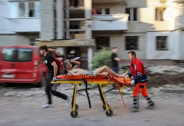 Healthcare personnel evacuate an injured resident at the site where an apartment building was hit by a Russian missile, as part of Russia's attack on Ukraine