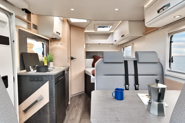 This compact motorhome features a dining area, kitchen, bedroom, and bathroom 