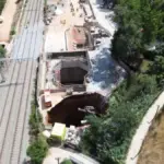 A sinkhole engulfs a crane at the undergrounding works in Montcada i Reixac