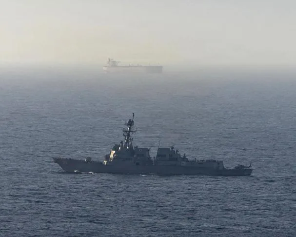 Trump can instantly shift from peace rhetoric to actual war, as in Iran. Pictured is a US guided-missile destroyer near a cargo ship in the Arabian Sea.
