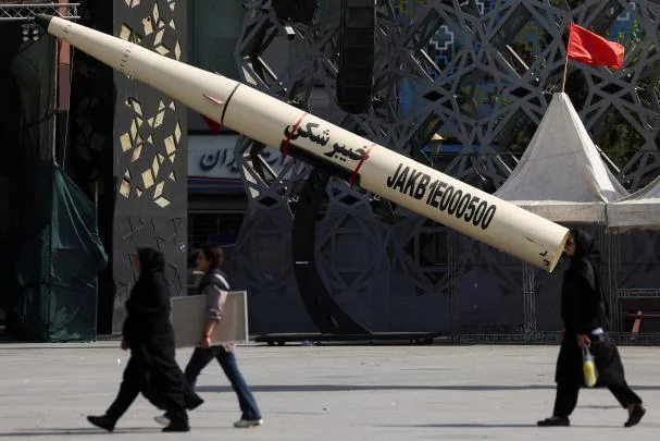 People walk next to a symbolic model of an Iranian missile in Imam Hussein square in Tehran, Iran 