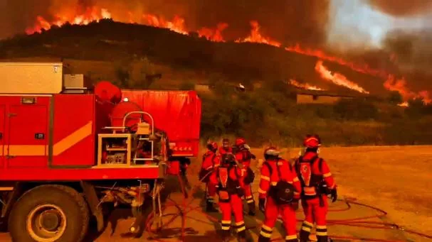 Firefighters working at the site after a forest fire in the municipality of Orés, in the north of the Aragón region