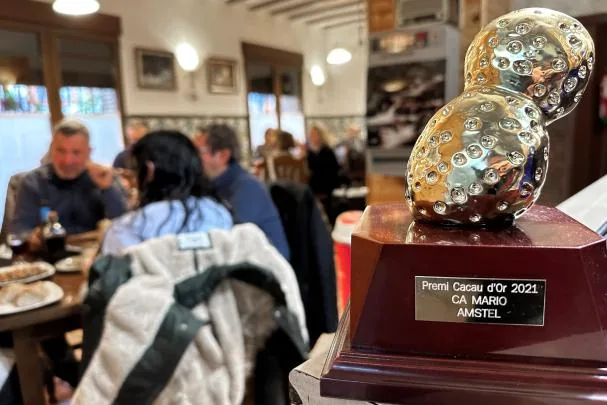 Several people have lunch next to the Cacau d'Or award.