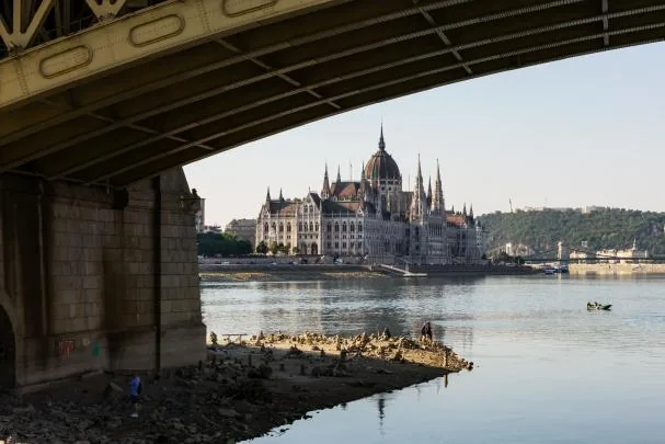 A drone image shows people walking at the foot of a pillar of the Margaret Bridge, visible due to the low water level of the Danube River in Budapest 