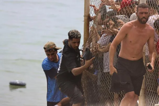 Young migrants crossing the border fence between Spain and Morocco last Thursday the 31st when the jump began