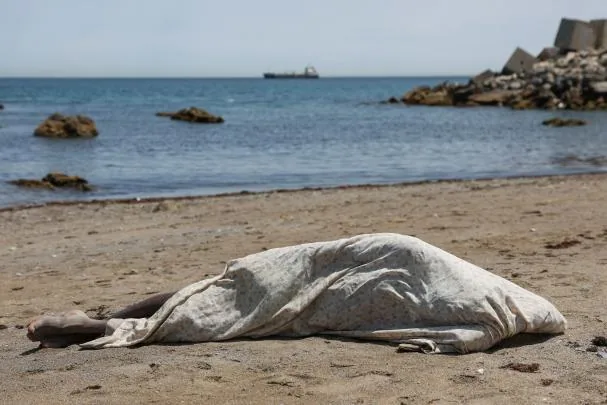 An immigrant sleeps on a beach in Ceuta 