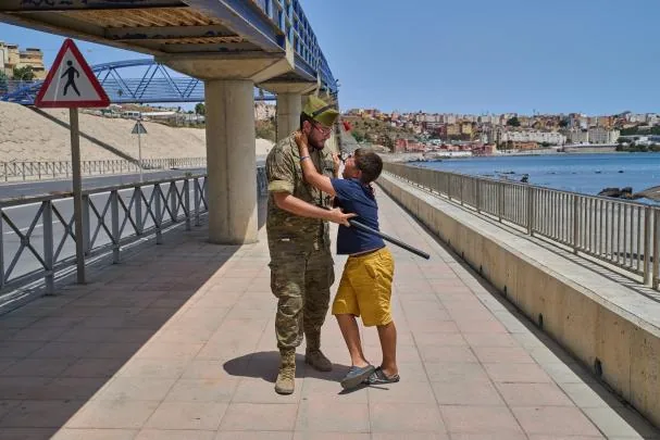 A 12-year-old boy throws his arms around a soldier in Ceuta 