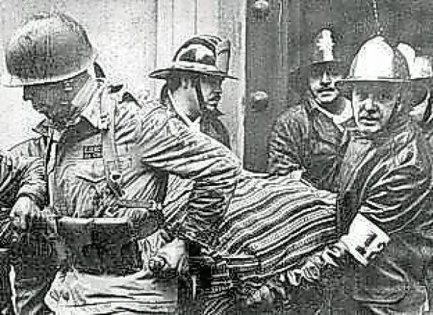 Soldiers carry the lifeless body of Salvador Allende