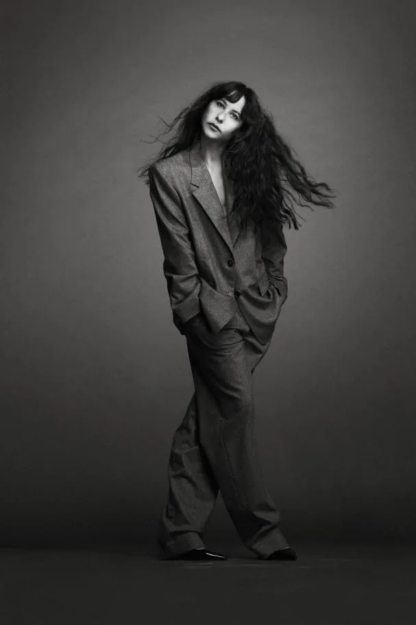 Gray tailored jacket and pants from the Flight Mode collection and black high-heeled shoes, all from Louis Vuitton