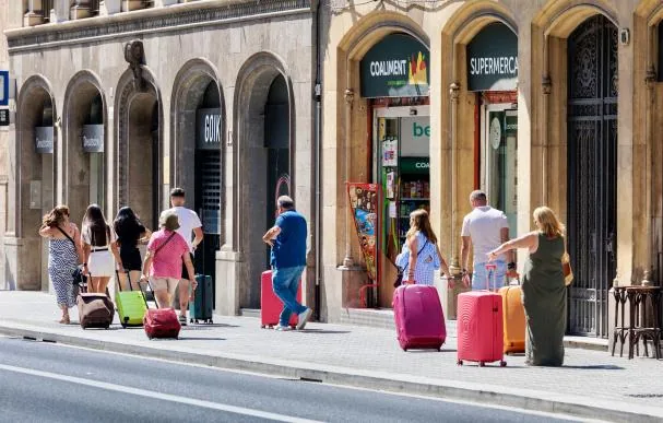 Turistas y sus maletas pasean por la Via Laietana